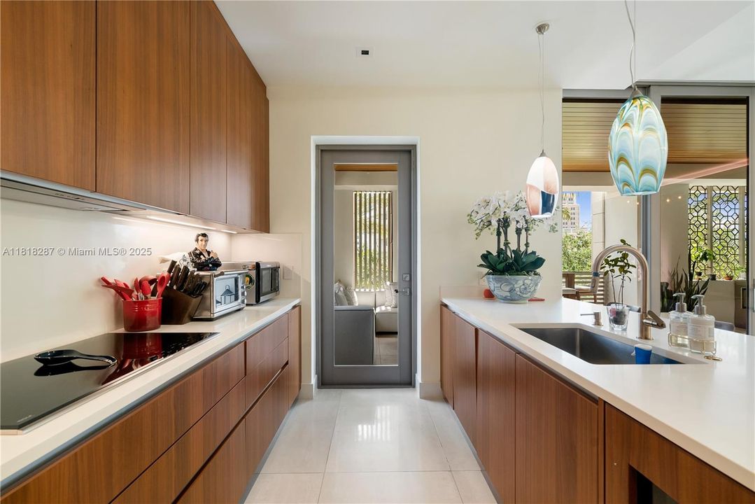 Well-appointed kitchen featuring extensive storage, integrated appliances, and a streamlined cooking area with under-cabinet lighting for a bright, functional workspace.