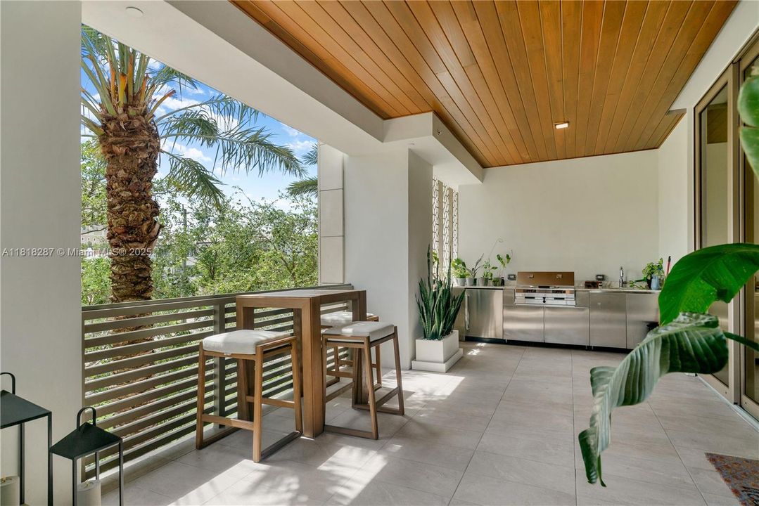 Outdoor area with dining space and surrounding tree views, offering a comfortable setting for open-air meals.