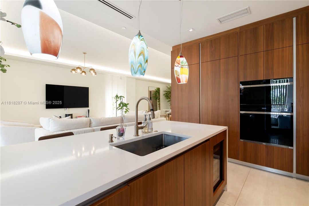 Expansive island with undermount sink overlooking the open living area, creating a smooth flow ideal for everyday living and entertaining.