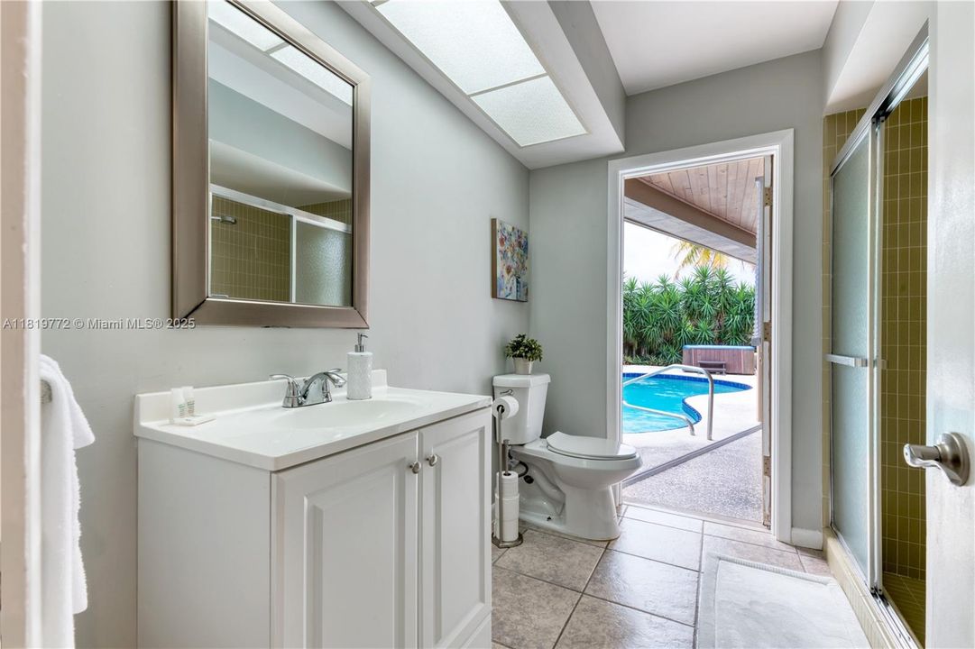 3rd Bathroom with a step-in shower, single vanity, and direct access to the pool deck
