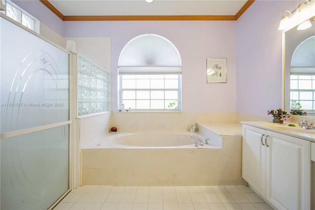 Spacious primary bathroom with dual sinks, jetted tub & separate shower.