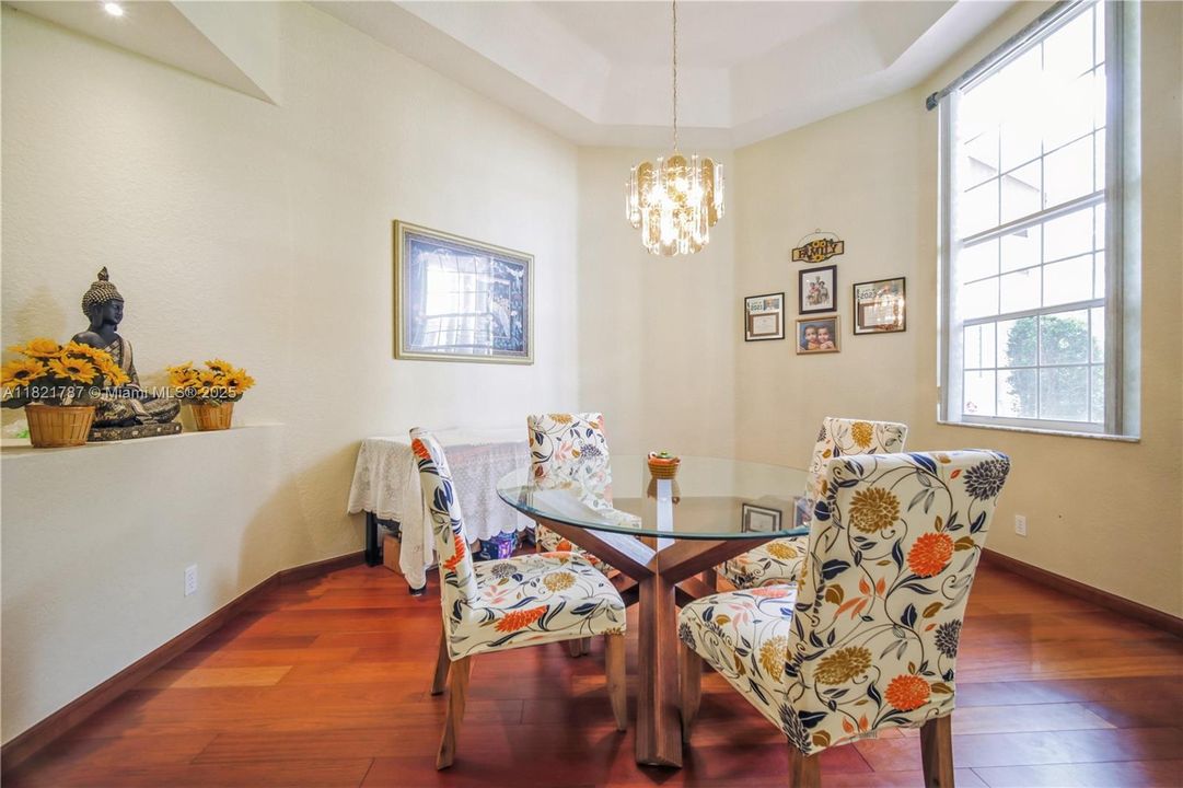 Dining room with beautiful wood floors & custom blinds in window.