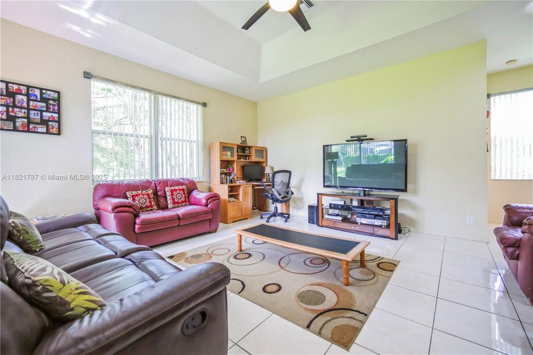 Huge family room great for tv/movie time and entertainment! High tray ceiling with fan & custom blinds on windows.