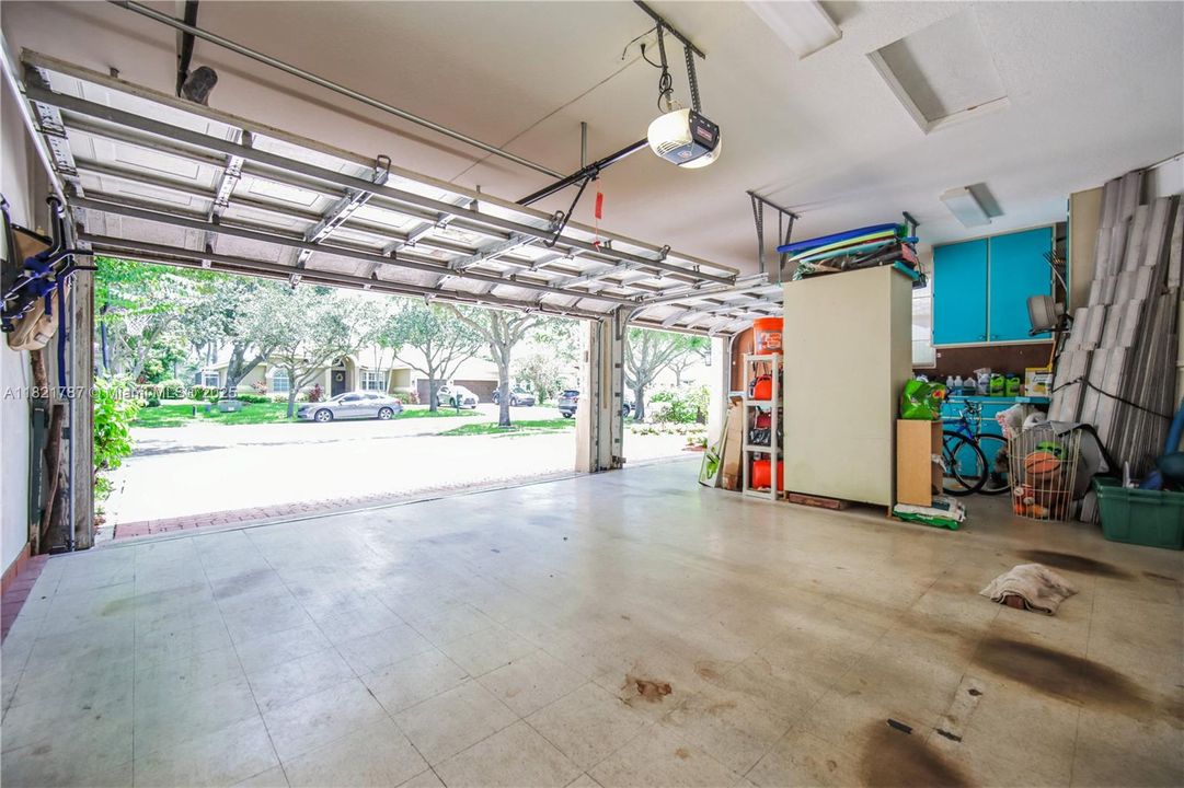 Spacious 3 car garage with built-in cabinetry for extra storage