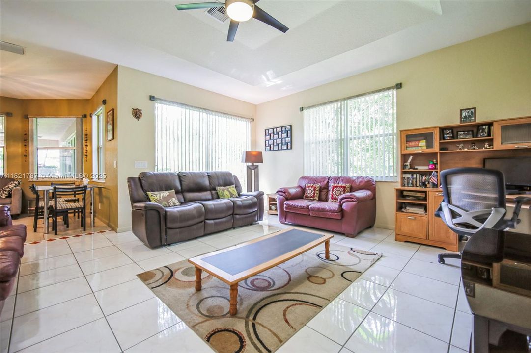 Huge family room great for tv/movie time and entertainment! High tray ceiling with fan & custom blinds on windows.