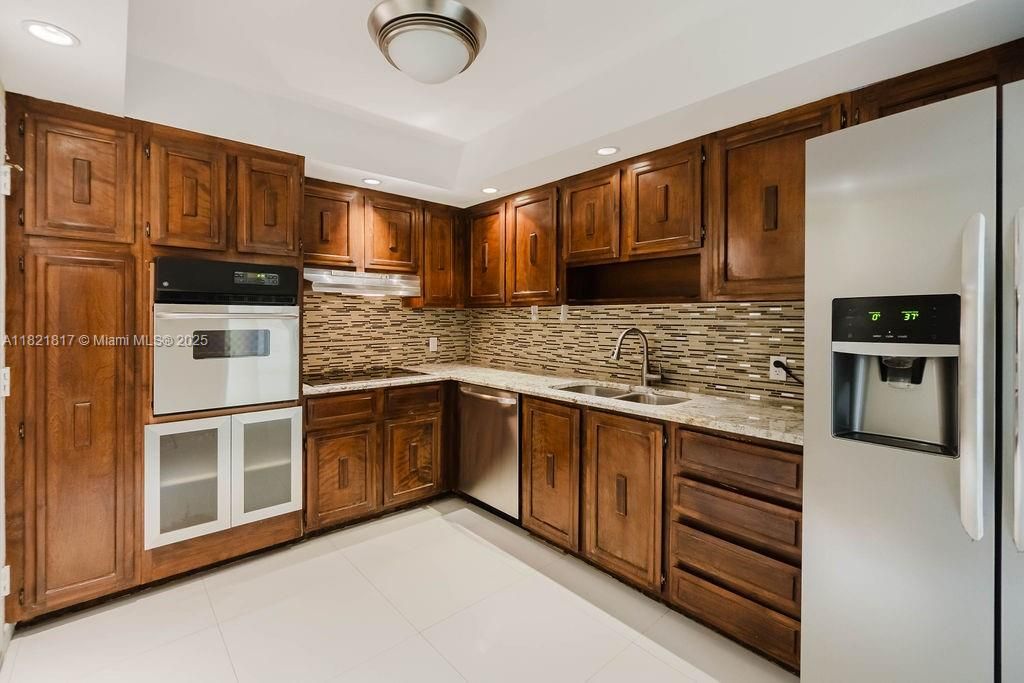 Updated kitchen with wood cabinets and modern lighting — a perfect blend of style and functionality in Miami Beach.