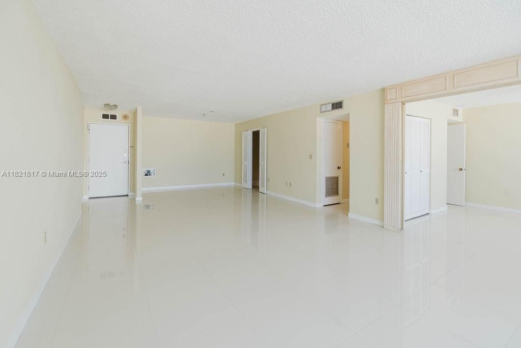 Open living space with sleek flooring and access to balcony — luxury condo living near South Beach and Venetian Islands.