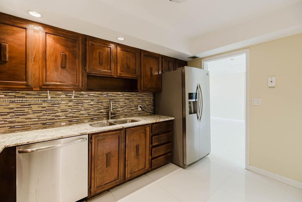 Spacious kitchen layout with open flow to dining area — great for entertaining in this Miami Beach waterfront condo.