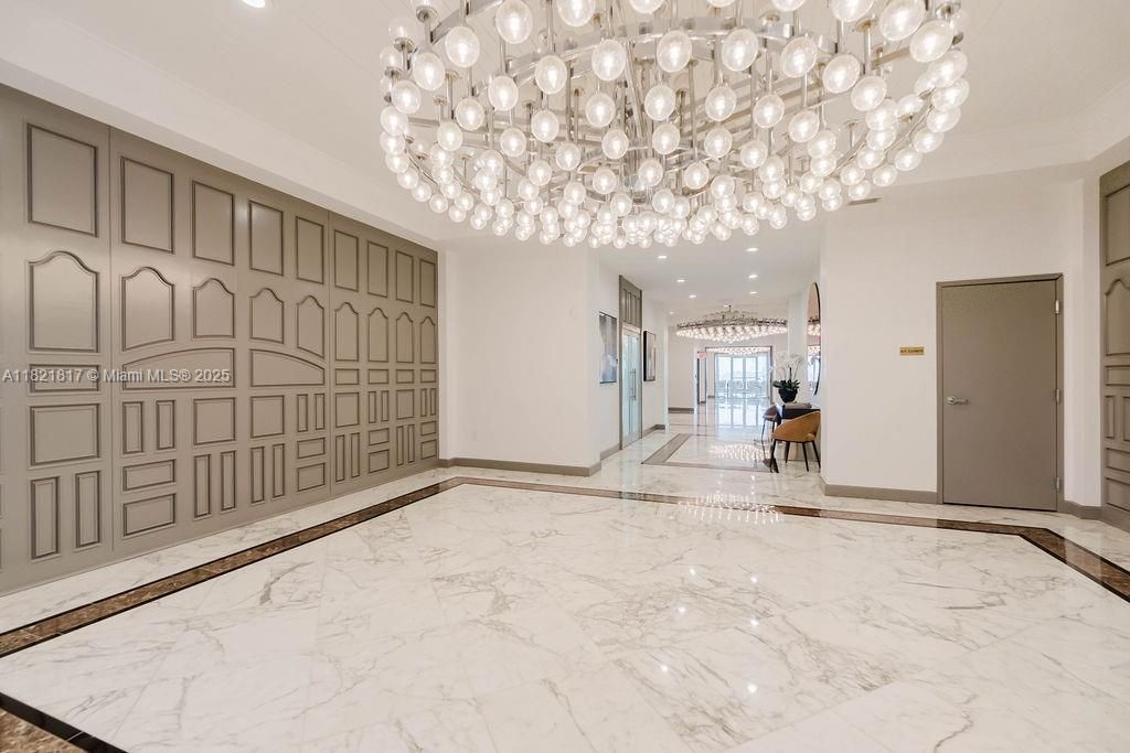 Lobby area with luxurious chandelier and elegant design — sophisticated atmosphere in a premier Miami Beach condo.