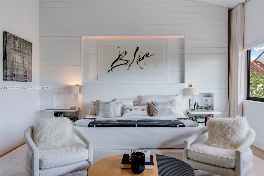 Expansive primary bedroom on the third floor filled with natural light and a cozy seating area.