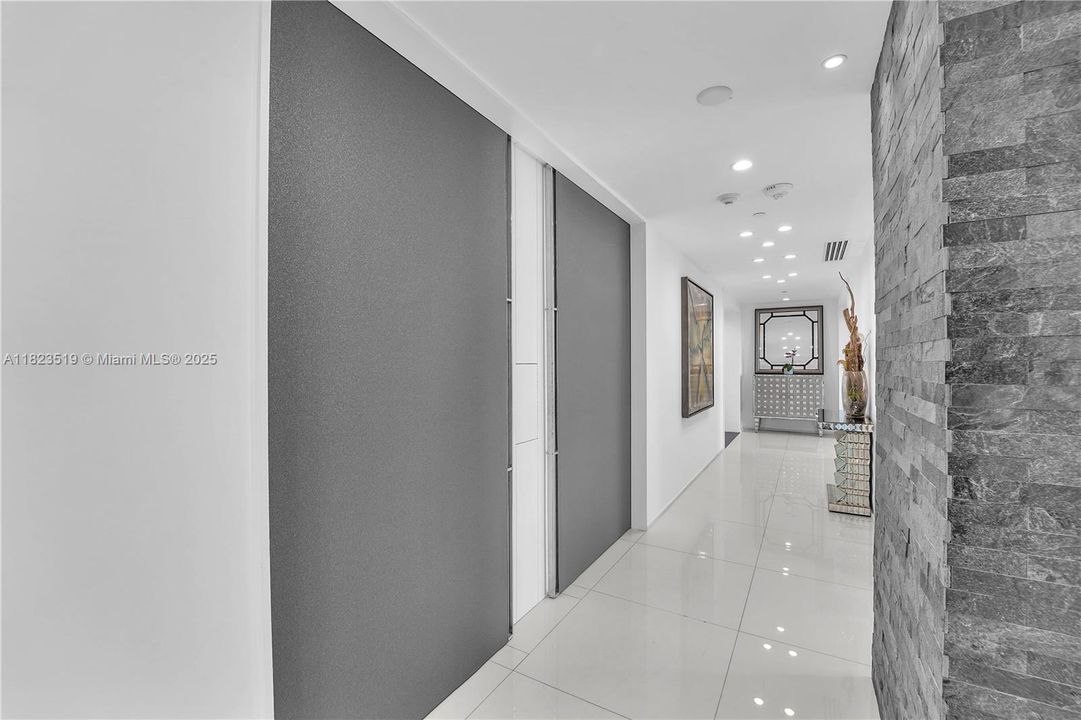 40' Long art entry foyer from two locked elevators towards the left with covering panels in shut position shown.