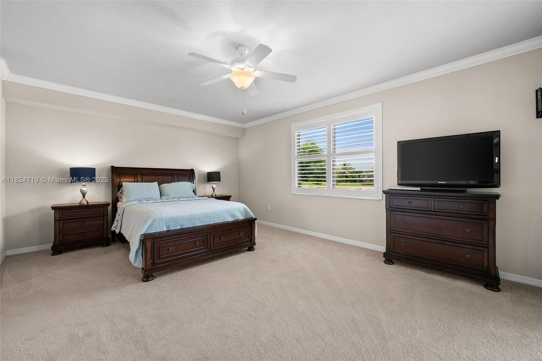 Spacious primary bedroom with crown molding