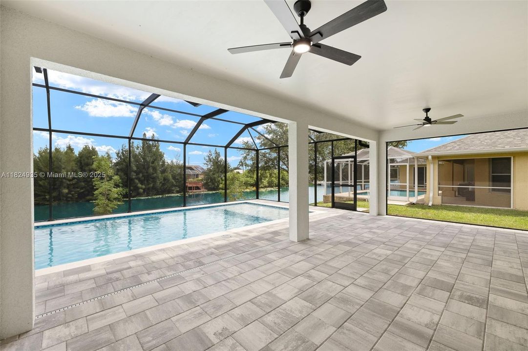 Large lanai area with pavers and canal/pool view