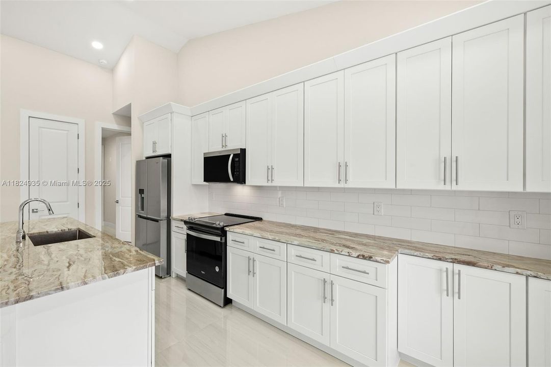 Kitchen - granite countertops, stainless steel appliances, tiled backsplash