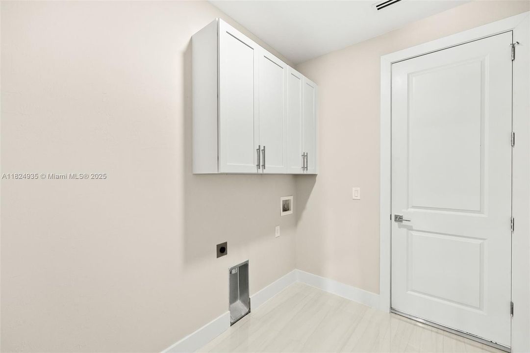 Inside laundry room with cabinets and washer/dryer hook up