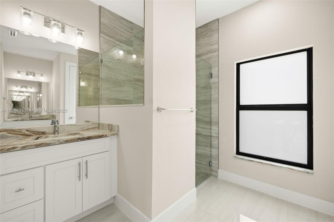 Primary Bathroom - dual sinks with granite countertops, tiled shower
