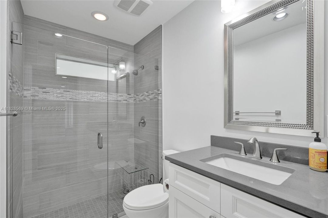Elegant third bathroom featuring a framed glass shower, high-end fixtures, and a beautifully appointed design for convenience and style.