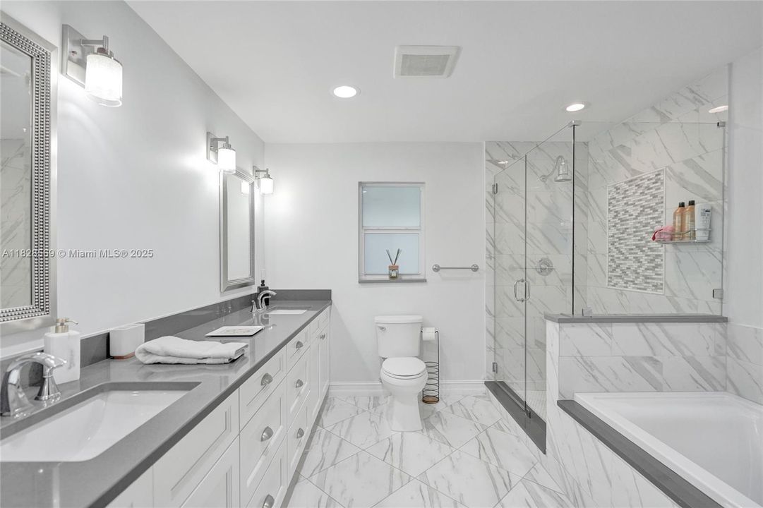 Primary bathroom features dual sinks, a separate fretless shower, and a soaking tub for a spa-like experience.