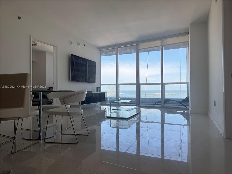 Spacious and bright living area with floor-to-ceiling windows showcasing panoramic bay views and sleek modern finishes.