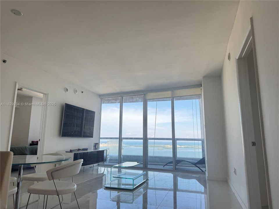 Open-concept layout with seamless flow between living and dining spaces, polished tile flooring, and abundant natural light.