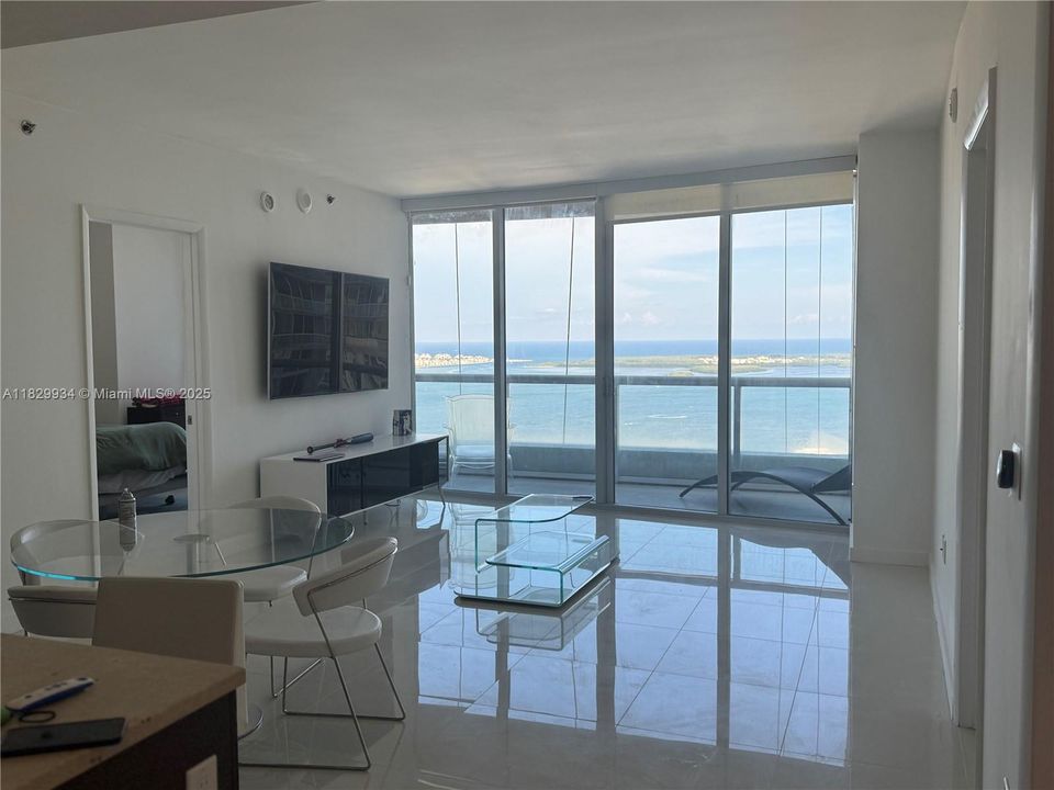 Alternate view of the main living area highlighting balcony access and the unobstructed Biscayne Bay backdrop.