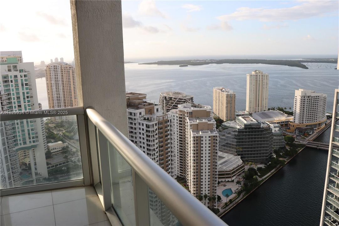 Taken from the secondary balcony, this perspective captures the dramatic blend of city and water views — showcasing the Brickell skyline, Biscayne Bay, and the Miami River below for a truly dynamic outlook.