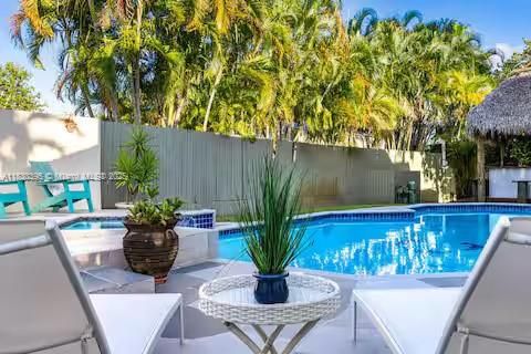 Resort-style pool with palm trees and poolside seating!