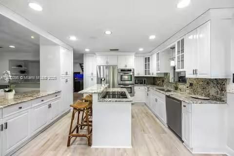 Sleek white kitchen with granite counters and tropical peekaboo views!