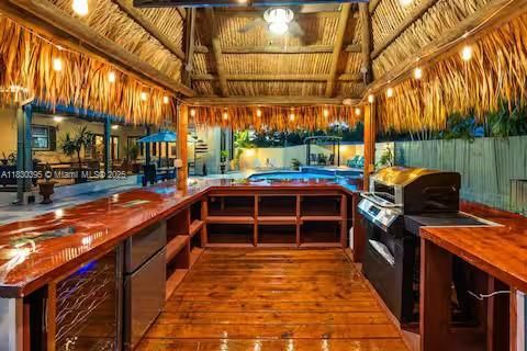 Tiki-style outdoor kitchen under palm thatch roof!