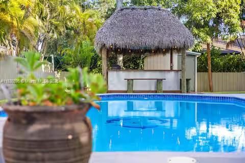 Thatched-roof tiki bar beside crystal blue pool!
