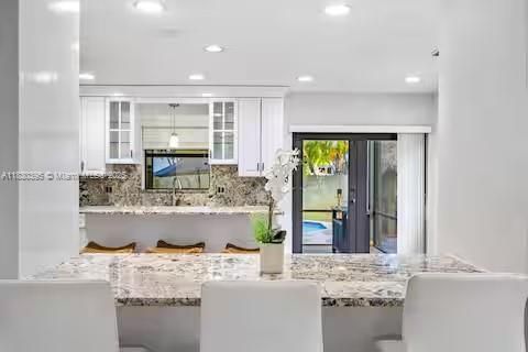 All-white kitchen paradise with granite waterfall island!