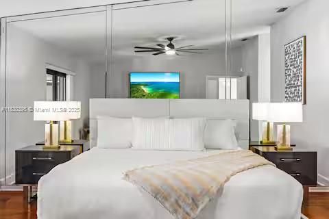 Mirror-backed headboard creates bedroom drama and space!