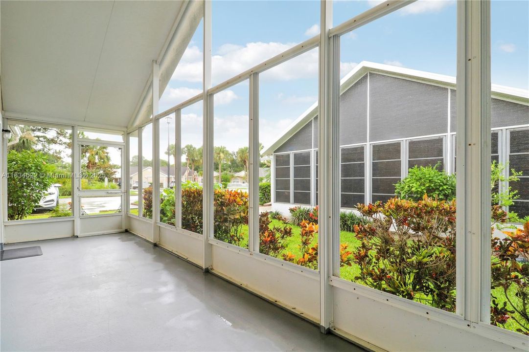Large covered screen room - doorway leads to parkin area
