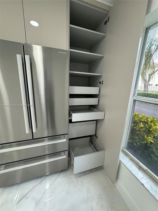 One of two full-height pantry cabinets with pull-out shelves