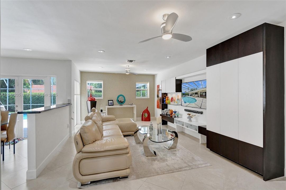 Lots of built in cabinetry for storage.....lighting in unit as well....French doors leads out to the pool