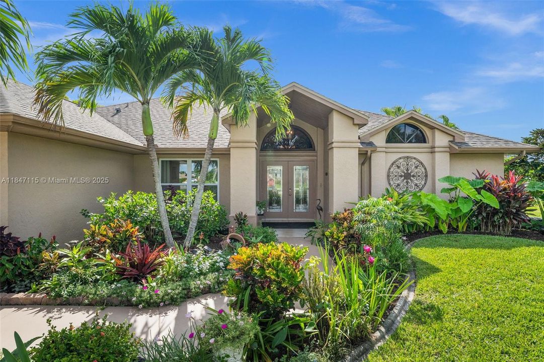 Lush tropical landscaping surrounds the home.