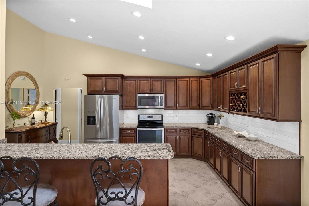 Granite countertops and stainless Whirlpool appliances elevate the kitchen.