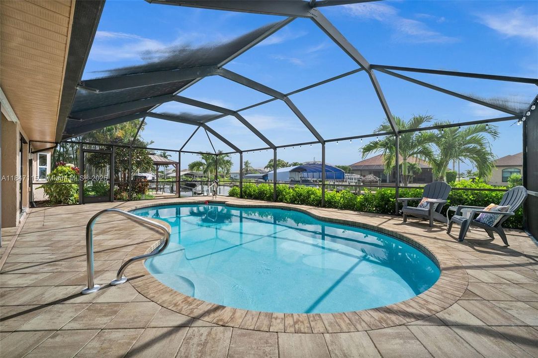 Patio pavers and screen surround the pool