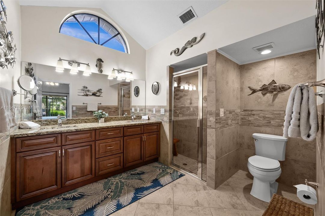 Master bath tiled with arched window