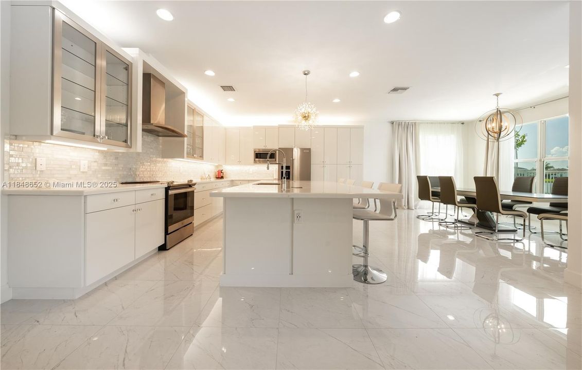 Open Floorpan | Over 350K in Upgrades | Kitchen & Dining Area w/ views to the Lake and the Pool area.