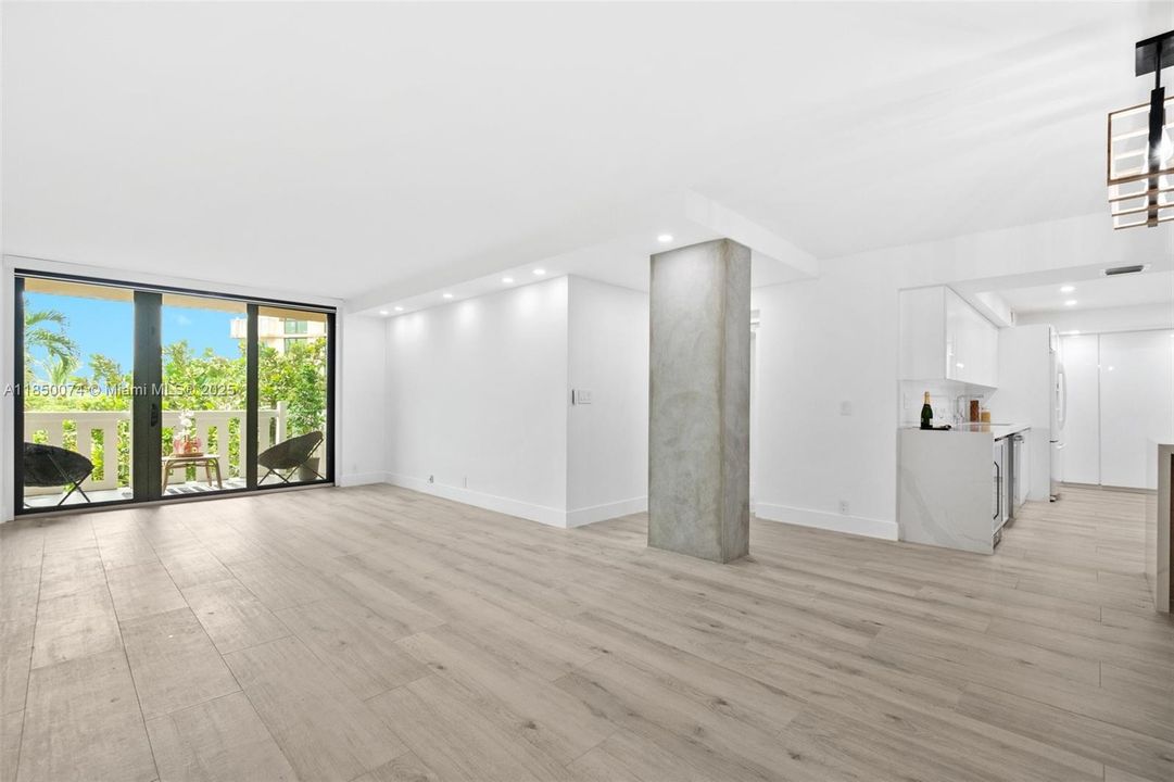 Open floor plan with high ceilings, abundant lighting, and ceramic tiles with a wood look.