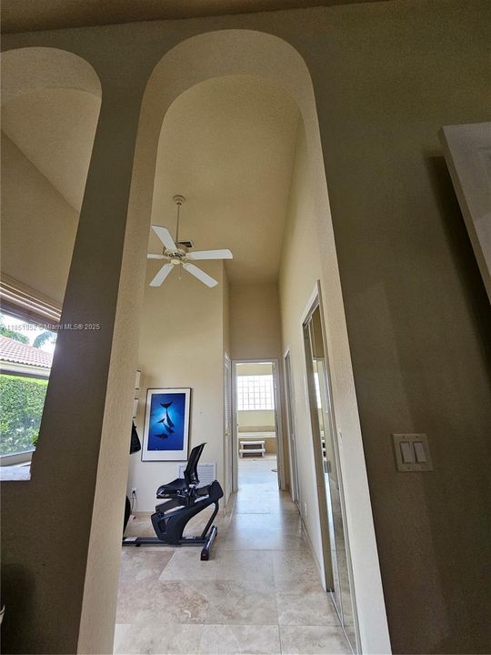 Arched opening from primary bedroom to sitting room, closets, ensuite bathroom