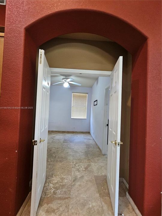 Arched double door entry to shared flex space between 2 ensuites