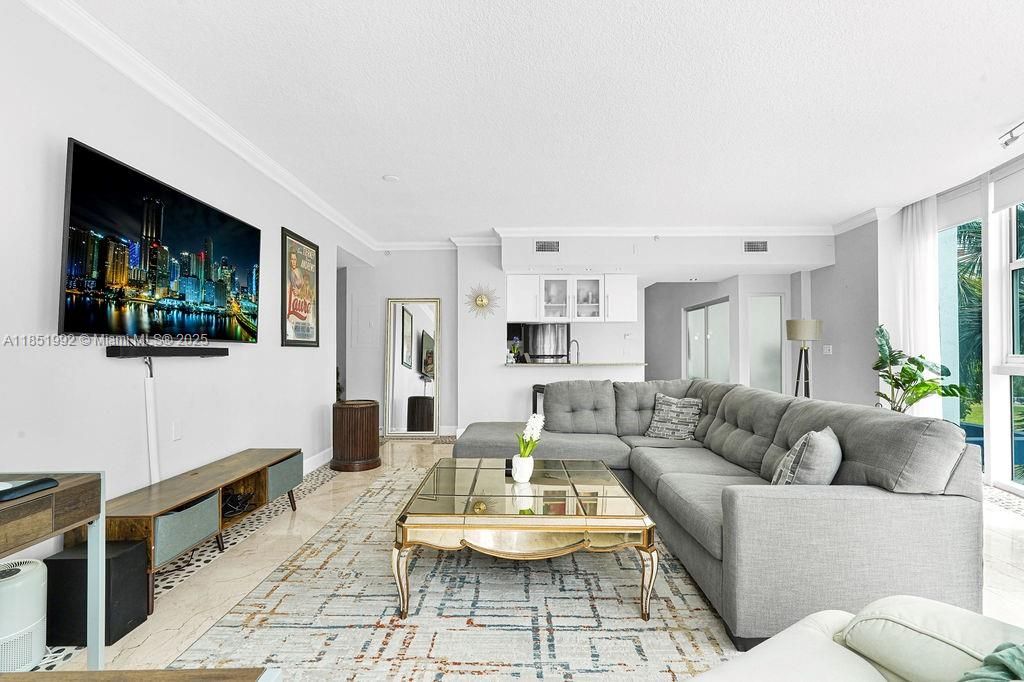 Bright and modern living area featuring floor-to-ceiling windows, abundant natural light, and open-concept design perfect for entertaining. Enjoy elegant finishes, neutral tones, and city views in this Miami high-rise condo near Biscayne Bay.