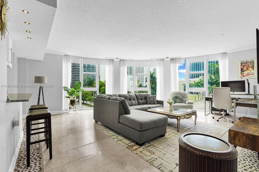 Bright and modern living area featuring floor-to-ceiling windows, abundant natural light, and open-concept design perfect for entertaining. Enjoy elegant finishes, neutral tones, and city views in this Miami high-rise condo near Biscayne Bay.