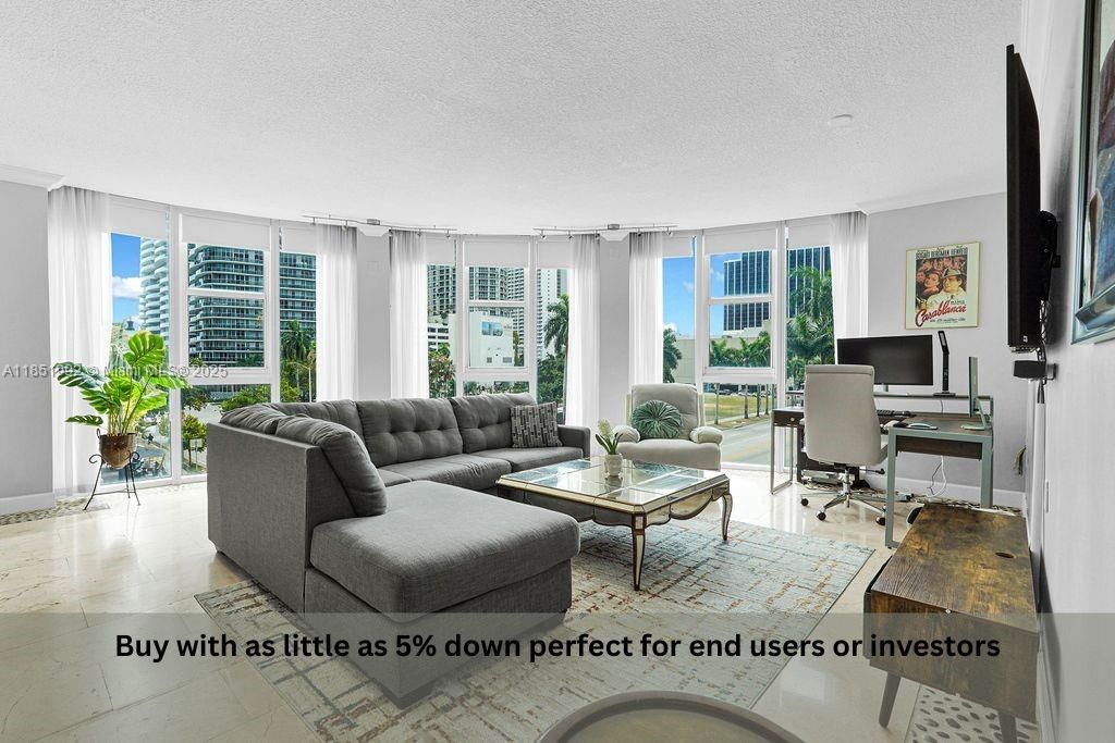 Bright and modern living area featuring floor-to-ceiling windows, abundant natural light, and open-concept design perfect for entertaining. Enjoy elegant finishes, neutral tones, and city views in this Miami high-rise condo near Biscayne Bay.