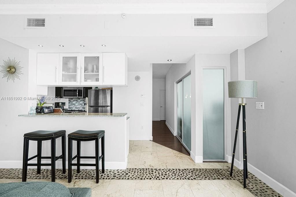 Sleek modern kitchen with stainless steel appliances, granite countertops, and contemporary cabinetry. Perfect for home chefs seeking a stylish and functional space.