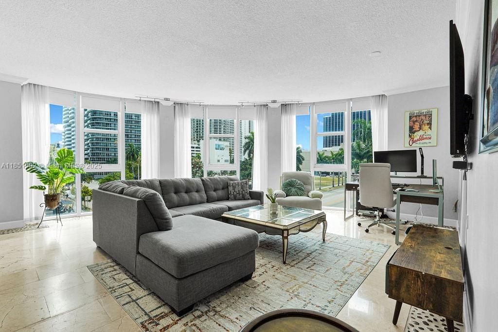Bright and modern living area featuring floor-to-ceiling windows, abundant natural light, and open-concept design perfect for entertaining. Enjoy elegant finishes, neutral tones, and city views in this Miami high-rise condo near Biscayne Bay.