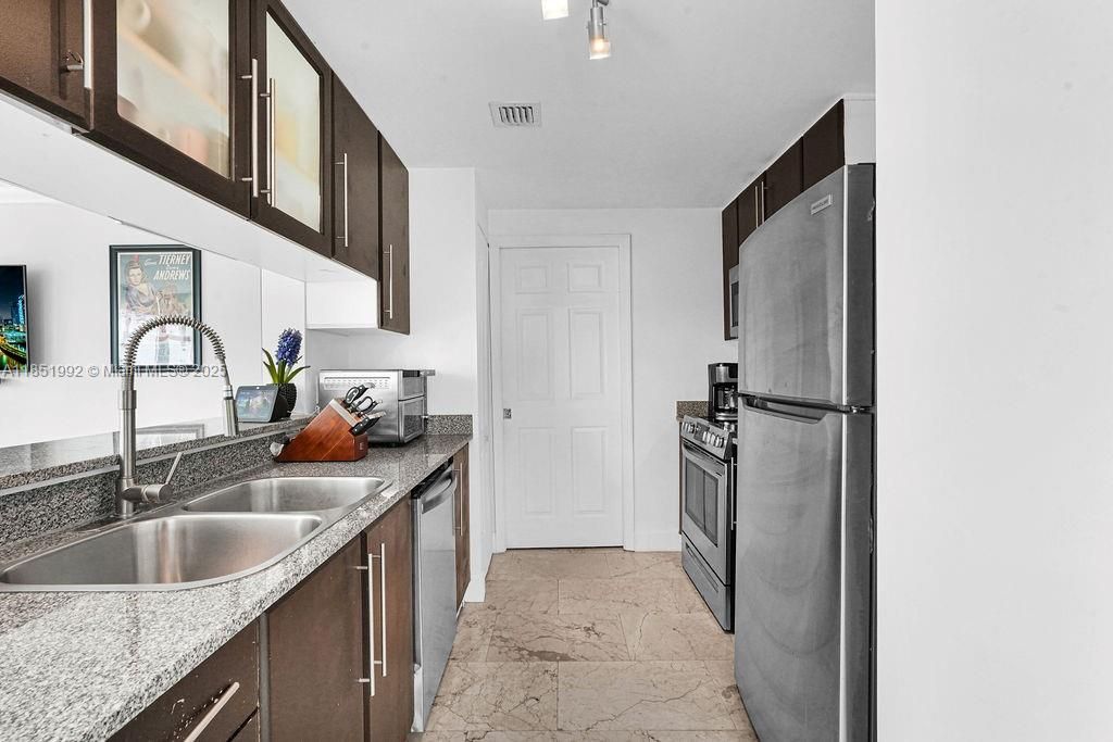 Sleek modern kitchen with stainless steel appliances, granite countertops, and contemporary cabinetry. Perfect for home chefs seeking a stylish and functional space.