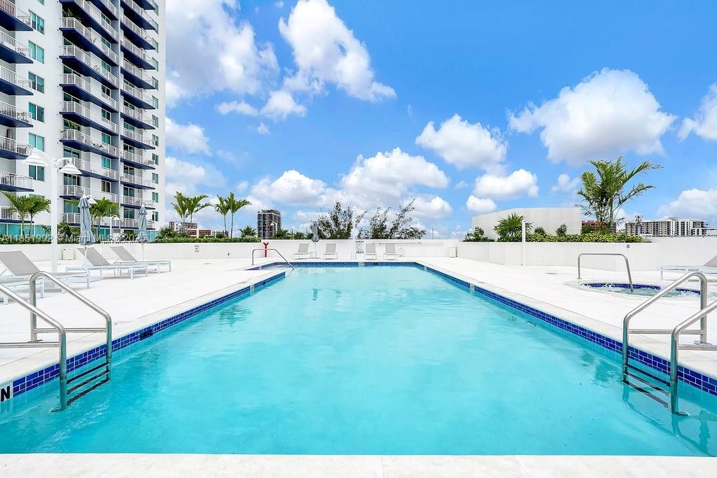 Resort-style pool with sun deck and tropical views, perfect for relaxing under the Miami sun.